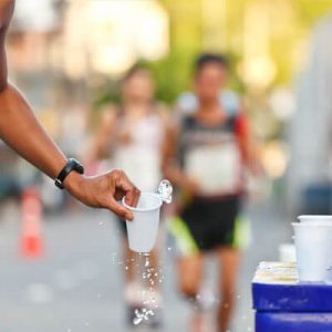 Marathon - Läufer nimmt sich einen Wasserbecher - Dramburg+Hertwig Getränkefachhandel